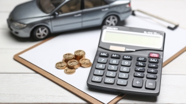 car model,calculator and coins on white table