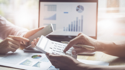 Business and partnership discussing using calculator to review balance sheet annual with holding pen and using laptop computer to calculating budget. audit integrity before investment concept.