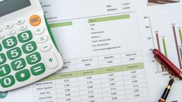 workplace-business-chart-showing-financial-success-with-pen-calculator (1)